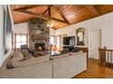 Cozy living room with wood-beamed ceilings, stone fireplace, and hardwood floors at 2004 Poplar Falls Rd, Lithonia, GA 30058