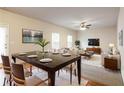 Elegant dining area with a large table, stylish chairs, modern lighting, and seamless flow to the living area at 2352 Allman Dr, Jonesboro, GA 30236