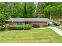 Beautiful brick home with a lush green lawn, mature trees, and a covered carport for convenience at 3050 Rebecca Sw Dr, Atlanta, GA 30311