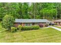 Well-maintained brick home with green shutters, mature trees, and a long driveway; ready for new owners at 3050 Rebecca Sw Dr, Atlanta, GA 30311