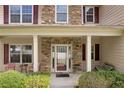 Inviting front porch with stone accents, seating, and manicured landscaping at 3178 Arbor Oaks Way, Snellville, GA 30039