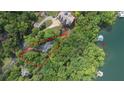 Breathtaking aerial view of a waterfront property surrounded by lush greenery and boat dock at 7830 Kings Point Dr, Cumming, GA 30041