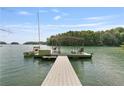 Waterfront property featuring a private dock with covered seating and a boat slip at 7830 Kings Point Dr, Cumming, GA 30041