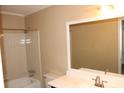 Well-lit bathroom with tub shower combination, light walls, and large mirror at 1457 Stoneleigh Cir, Stone Mountain, GA 30088