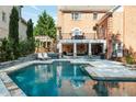 Luxurious backyard oasis featuring a pristine pool, stone patio, and outdoor seating area perfect for relaxation at 3003 W Roxboro Rd, Atlanta, GA 30324