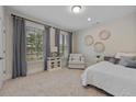Comfortable bedroom featuring large windows, neutral tones, carpeted floor and a cozy sitting area at 2062 Cortland Rd, Milton, GA 30009