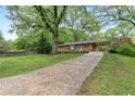 A home with green lawn and mature trees, featuring a covered carport at 2337 Elmwood Se Cir, Atlanta, GA 30339