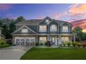 Beautiful twilight view of a two-story home with manicured lawn, stone accents and gray siding at 2625 Blackstock Dr, Cumming, GA 30041