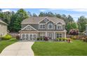 Charming two-story home with gray siding, stone accents, and a well-manicured lawn at 2625 Blackstock Dr, Cumming, GA 30041