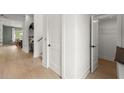 Hallway with hardwood floors and white walls, leading to additional rooms and closet space at 326 Treble Way, Alpharetta, GA 30009