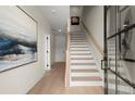 Inviting entryway features light hardwood floors, white stairs, and a striking modern art piece at 435 Mezzo Ln # 86, Alpharetta, GA 30009