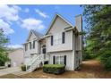 View of the side of the home showing gray siding, windows with black shutters, and landscaping at 7832 Cambridge Dr, Douglasville, GA 30134