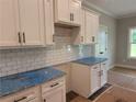 A new kitchen featuring white cabinets, black hardware, and granite countertops at 877 Highway 101 N, Dallas, GA 30157