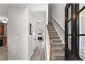 Inviting foyer with hardwood floors, staircase, and views into the kitchen and living room at 1237 Park Pass Way, Suwanee, GA 30024