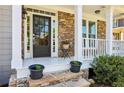 Inviting front porch showcasing stone detail, black front door, and charming accents at 4360 Havenridge Pl, Cumming, GA 30041