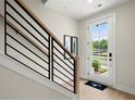 Modern staircase with black metal railing and natural wood accents leading to a white door at 439 Mezzo Ln # 88, Alpharetta, GA 30009