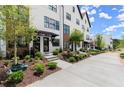 Townhome exterior featuring black framed windows, freshly landscaped yards, and concrete sidewalks at 654 Soul Aly # 102, Alpharetta, GA 30009