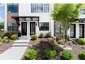 Townhome landscaped front yard featuring a concrete walkway and well-maintained plantings at 654 Soul Aly # 102, Alpharetta, GA 30009
