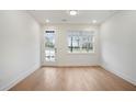 Bright, airy living room with hardwood floors and large window, perfect for relaxation at 654 Soul Aly # 102, Alpharetta, GA 30009