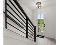 Bright entryway with black metal railing and a clear view of the outdoors through the front door at 673 Soul Aly # 146, Alpharetta, GA 30009