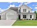 Beautiful two-story home featuring white brick, siding, a three-car garage, and a green lawn at 3548 Cedarvale Ct, Powder Springs, GA 30127
