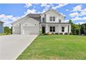 Stunning two-story home with white brick, siding, three-car garage, and well-manicured lawn at 3548 Cedarvale Ct, Powder Springs, GA 30127