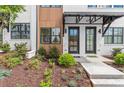 Inviting entrance of a townhome with manicured landscaping and modern exterior design at 656 Soul Aly # 101, Alpharetta, GA 30009