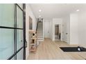 Bright entryway with light hardwood floors, staircase, and a view of the bathroom at 656 Soul Aly # 101, Alpharetta, GA 30009