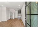 Inviting living room with hardwood floors, staircase, and bathroom access at 656 Soul Aly # 101, Alpharetta, GA 30009