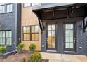 Inviting townhome entryway featuring a black brick facade and a stylish black awning at 656 Soul Aly # 101, Alpharetta, GA 30009