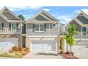 Charming townhome showcases a well-manicured lawn, a two-car garage, and beautiful landscaping at 7678 Gray Pointe Dr, Lithonia, GA 30058