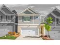 Charming townhome showcases a well-manicured lawn, a two-car garage, and beautiful landscaping at 7678 Gray Pointe Dr, Lithonia, GA 30058