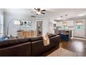 Open-concept living space featuring a large brown leather couch, wood floors, and bar-stool seating to the kitchen island at 2171 Plantation Ln, Chamblee, GA 30341