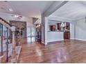 Open-concept living space featuring a stone fireplace, hardwood floors, and seamless flow to the kitchen area at 2347 Univeter Rd, Canton, GA 30115