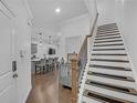 Open-concept entryway showcases hardwood floors, a staircase, and a view into the modern kitchen and living area at 360 Niles Ct, Marietta, GA 30060