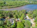 Aerial view showcases the wooded, waterfront properties with pools and privacy on a bright, sunny day at 9355 Huntcliff Trce, Sandy Springs, GA 30350