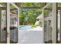 View from inside the home to the refreshing backyard pool, patio and lush green landscaping at 9355 Huntcliff Trce, Sandy Springs, GA 30350