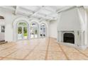 Spacious living room features tile flooring, coffered ceilings, a decorative fireplace and French doors to the backyard at 9355 Huntcliff Trce, Sandy Springs, GA 30350