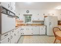 Bright eat-in kitchen features white cabinetry, vintage appliances, laminate counters, and patterned flooring at 3501 Montreal Way, Tucker, GA 30084