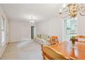 Open-concept living and dining area with chandelier, sofa, and view into kitchen at 3501 Montreal Way, Tucker, GA 30084