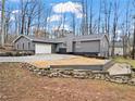 Well-maintained gray single story home with landscaped yard featuring a tiered stone retaining wall at 1925 Commonwealth Ct, Cumming, GA 30041