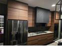 Modern kitchen featuring flat-panel wood cabinets, granite countertops, and a stainless steel refrigerator at 225 Nacoochee Dr, Woodstock, GA 30188