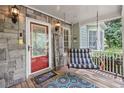 Inviting front porch featuring stone accents, a hanging swing, and a cheerful welcome sign at 24 Picketts Mill Pl, Acworth, GA 30101