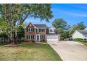 Traditional two-story home featuring a brick facade, attached garage, and a well-maintained front lawn at 651 Deer Oaks Dr, Lawrenceville, GA 30044