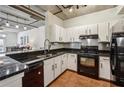 White cabinetry, granite countertops, and stainless steel appliances in a naturally lit kitchen at 800 Peachtree Ne St # 2304, Atlanta, GA 30308
