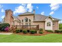 Spacious backyard featuring a wooden deck, lush lawn, and detailed brickwork on the house at 1364 Gulfport Run, Grayson, GA 30017