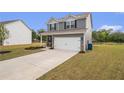 Attractive gray home with a well-maintained lawn and a convenient two-car garage at 231 Limestone Cir, Conyers, GA 30013