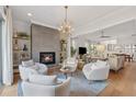 Open-concept living room with a cozy fireplace, stylish chandelier, and comfortable seating at 260 Jasmine Garden Way, Alpharetta, GA 30009