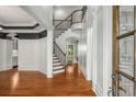Elegant foyer featuring hardwood floors, a staircase with iron railings, and custom wall paneling at 201 Hunley Ct, Alpharetta, GA 30005