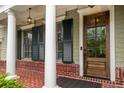 Inviting front porch with brick flooring, white columns, and a wood door with glass inserts at 201 Hunley Ct, Alpharetta, GA 30005